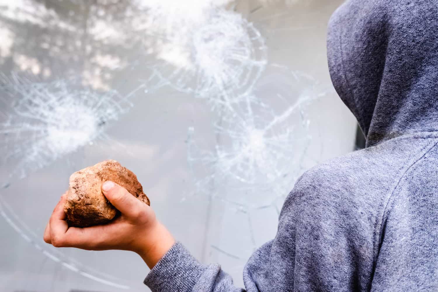 child holds a stone to throw it against a glass an 2022 05 23 23 12 35 utc