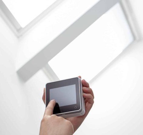 Hand operating a Remote control of a roof windows on indoor. Home automation. Copy space